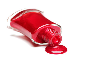 Red nail polish spilling from a bottle
