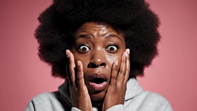 Shocked Black Woman With Afro Hair Wearing Hoodie Expressing Surprise.