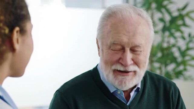 Elderly caucasian man and young mixed-race female doctor in a warm, genuine consultation at a modern medical facility with bokeh background, concept of empathetic healthcare