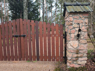 wooden gate, entrance to the cemetery. Stone gateposts. Jaunzemju Cemetery, Latvia, Zemgale