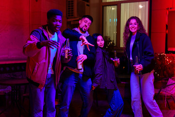 Friends celebrate together in lively indoor setting with colorful lighting at night