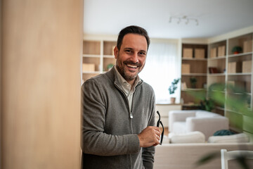 Obraz premium Happy man smiling holding glasses at home