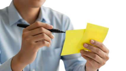 Hands writing important reminder on yellow sticky note with marker