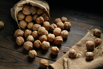 Walnuts on an old rustic table. Walnuts in a paper bag.walnuts on a jute napkin
