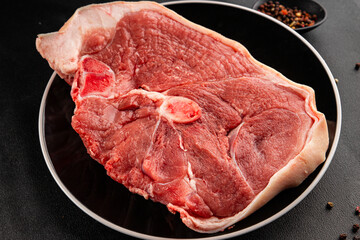 Bone-in ham steak, raw pork ham on the bone tasty snack fresh gourmet food background on the table  rustic food top view copy space