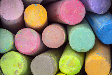 Close-up of stacked colorful chalk sticks showing various bright hues with textured surfaces in a tightly packed arrangement