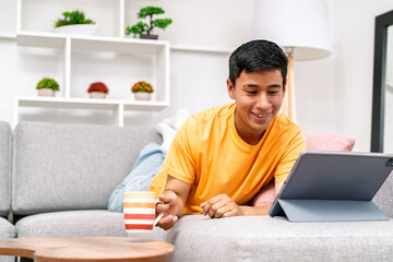 Young man relaxing on couch using tablet