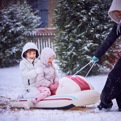 Playful Siblings Enjoying a Sled Ride Pulled by Their Big Brother on a Snowy Winter Day. Fun Family Activity in Motion.