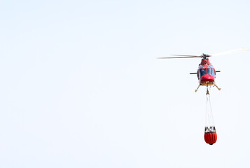 Firefighting Helicopter Carrying Water in Clear Sky