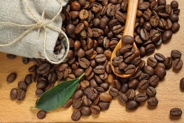coffee beans sprinkled on a wooden board .wooden spoon with coffee beans