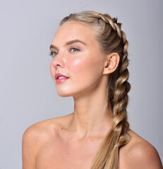 Beautiful face of young adult woman with clean fresh skin.  Has a braided hairstyle