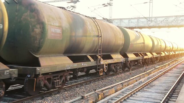 An Indian freight train carrying oil tanker wagons stands on railway tracks. The scene highlights industrial transport, fuel logistics, and rail infrastructure in India.
