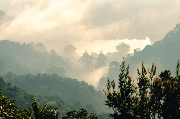 A beautiful landscape of rolling mountains, water sources and mist floating above the trees. A rural view of Phayao Province, Northern Thailand.