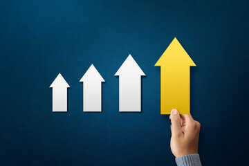 A man hold carry yellow arrow pointing upwards. represents development path direction success statistics growth aim achievement
