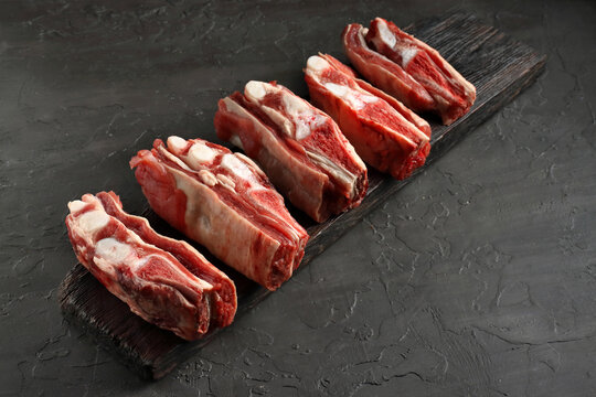 fresh beff ribs on a board.black background