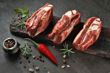 raw beef ribs with spices and herbs on a stone background.top view.