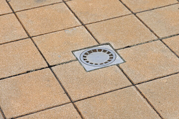 Clogged Drain Cover at Tiles Pavement in Garden