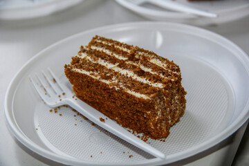 pieces of chocolate cake with white cream lying on plates, birthday, disposable tableware, forks, dessert,