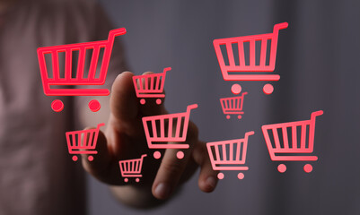 Person's finger interacting with online shopping carts. Represents e-commerce, digital retail, and online purchasing with emphasis on technology