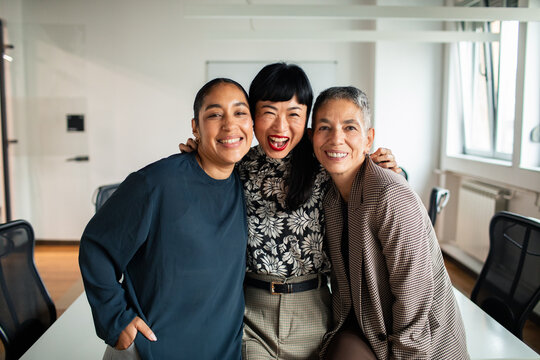 Adult and mature women colleagues laughing together in modern office