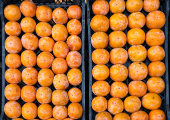 Fresh ripe persimmons displayed in crate.
