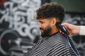 Man getting curly fade haircut in barbershop