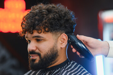 Man getting curly hair fade haircut at barbershop