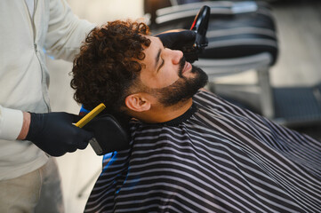 Barbershop client receiving professional haircut and beard trim