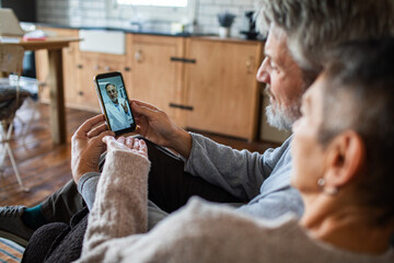 Senior couple concerned on telehealth call at home kitchen