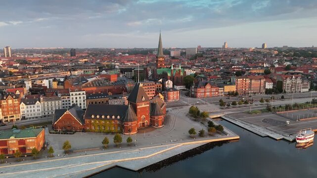 Aerial shot of city skyline with historic buildings and waterfront activities in Aarhus during sunrise. Aarhus - second-largest city in Denmark in the morning