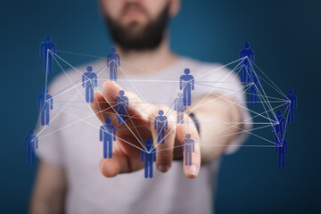 Man's hand pointing at digital human network and connection representing teamwork and global community.