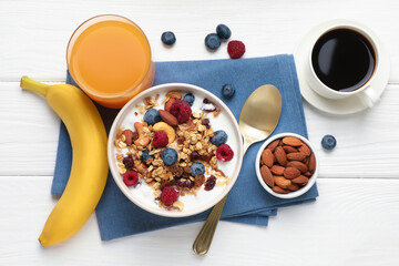 Healthy breakfast. Oatmeal with nuts, berries and milk served on white wooden table, flat lay
