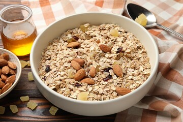 Making granola. Oat flakes, dried fruits, almond nuts and honey on wooden table, closeup