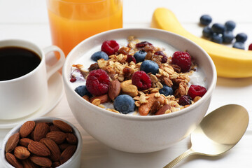 Healthy breakfast. Oatmeal with nuts, berries and milk on white wooden table, closeup