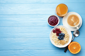 Healthy breakfast. Oatmeal with nuts, banana, berries, jam, coffee and juice served on light blue...