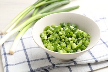 Whole and cut fresh green onions on table, closeup