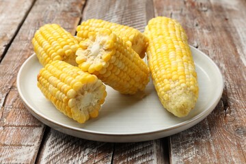 Pieces of boiled corncobs on wooden table, closeup