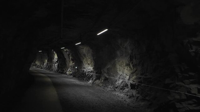 POV walking through dim mining tunnel with rough stone walls