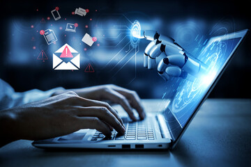 Obraz premium A robot hand reaches out to interact with a laptop, displaying digital notifications and an email alert, illustrating the fusion of technology and innovation in modern communication. Gantry
