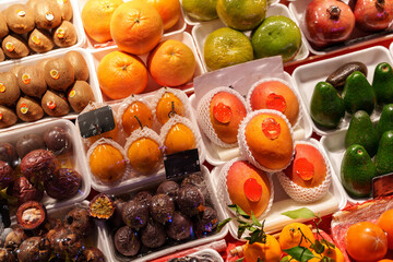 Colorful display of fresh fruits at a bustling market in a vibrant city during the daytime