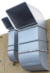 Two industrial ventilation pipes on a wall