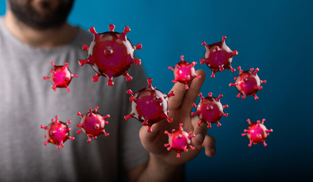 Conceptual image of a man touching floating coronavirus, showing the spread of viruses and disease, or scienti