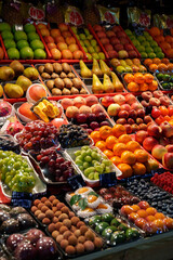 Vibrant fruit display at a bustling market during daylight in a lively urban setting