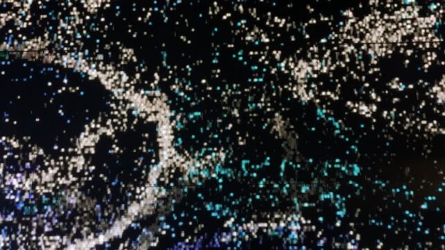 Footage of interactive led screen graphic playing colorful sand and sparkling grains of waves streaming randomly with wavy direction. Led lights play, modern technology. In blue, black, and white colo
