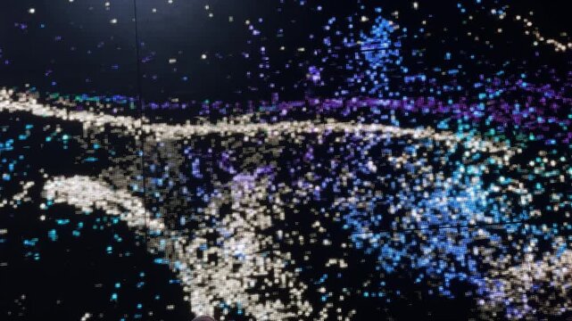 Footage of interactive led screen graphic playing colorful sand and sparkling grains of waves streaming randomly with wavy direction. Led lights play, modern technology. In blue, black, and white colo