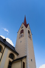 Church tower of the Parish Church Saint Margaret in Welsberg/Monguelfo against blue sky