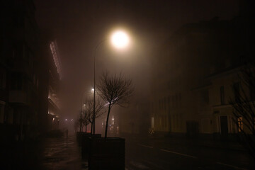 Street lights in mist. Autumn night with rain in the city