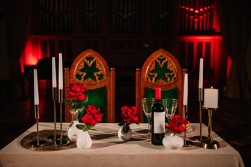 Dinner setup. Location for surprise proposal at night. Luxury romantic date. Decoration, flower, burning candles. Table setting in restaurant for the event. Candlelight for couple on Valentine's day.