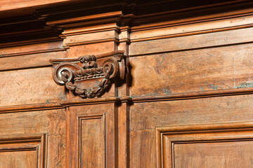 Detail of an old carved italian wooden furniture with floral elements just restored
