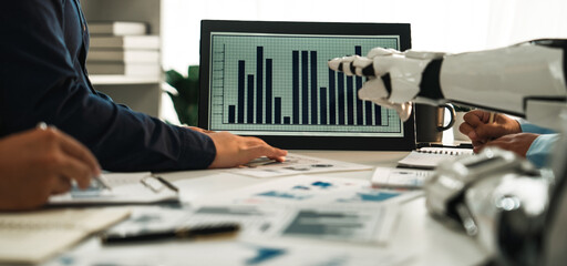 A dynamic scene showcasing a collaborative business meeting where human hands and a robotic arm analyze data presented on a screen, emphasizing teamwork and innovation.Noogenesis
